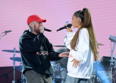 Ariana Grande, wearing white sweatshirt and Mac Miller on stage together