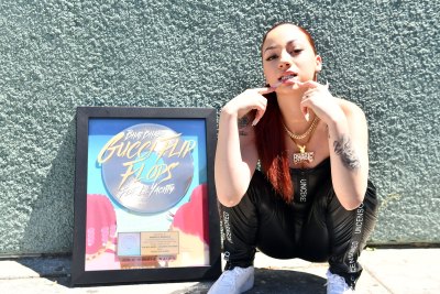 Danielle Bregoli outside with a record, wearing black pants