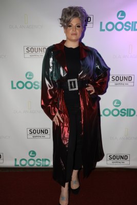 Kelly Osbourne at an event, wearing a long robe and belt