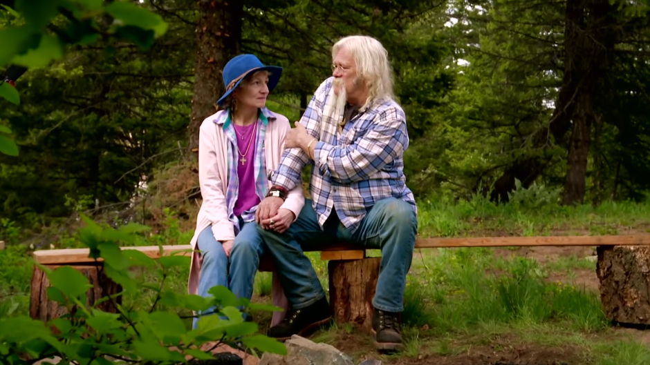 Ami And Billy Brown holding hands on a bench in the woods
