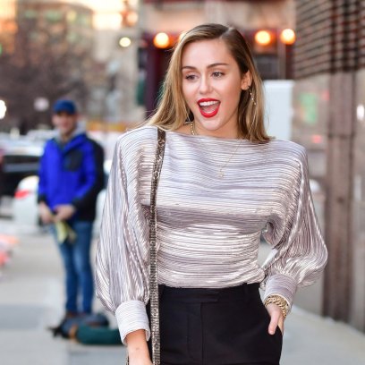 Miley Cyrus wearing a silver shirt while out in NYC