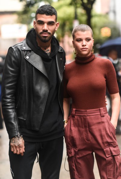 Sofia Richie wearing a maroon outfit with brother Miles Richie, in a black leather jacket