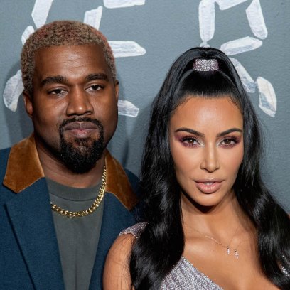 Kim Kardashian wearing a silver dress with Kanye West