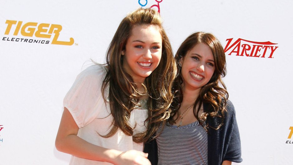 Miley Cyrus wearing a white shirt with Emma Roberts, wearing a striped shirt