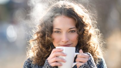 Brunette woman in pullover drinking hot tea