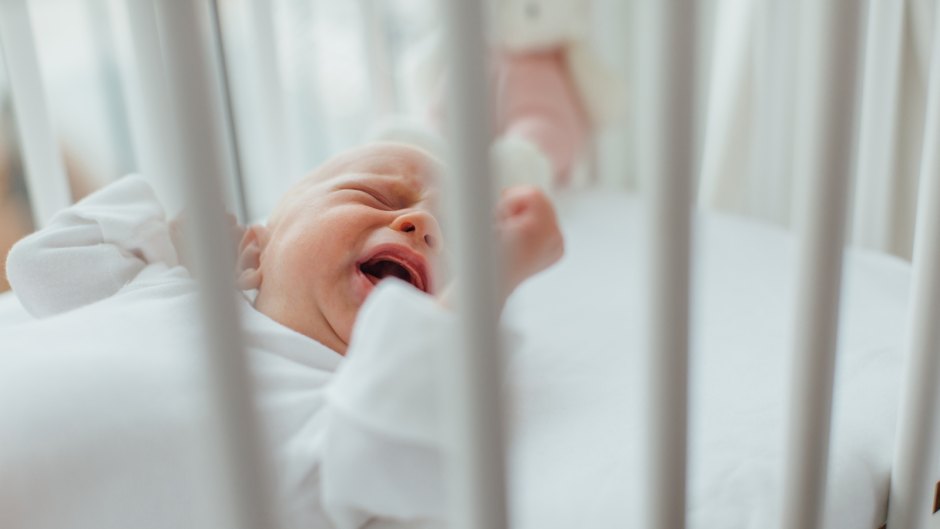 Baby lying in crib crying