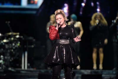 Kelly Clarkson wearing all black singing