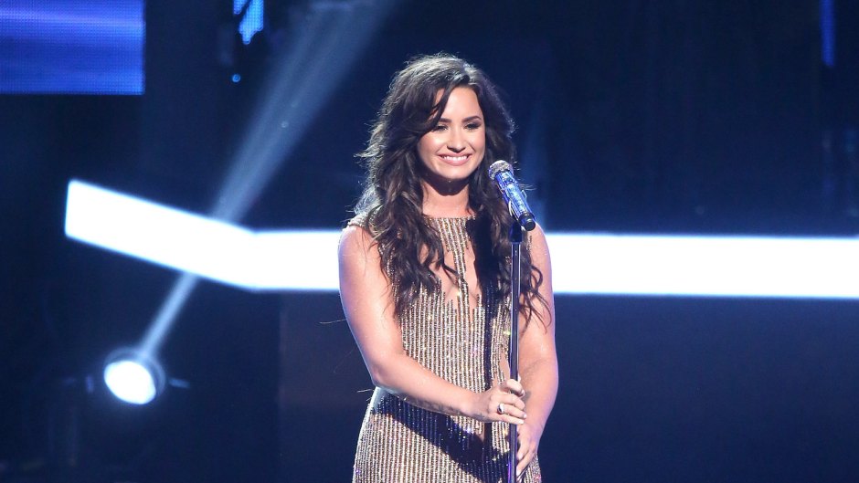 Demi Lovato on stage wearing a sparkly dress