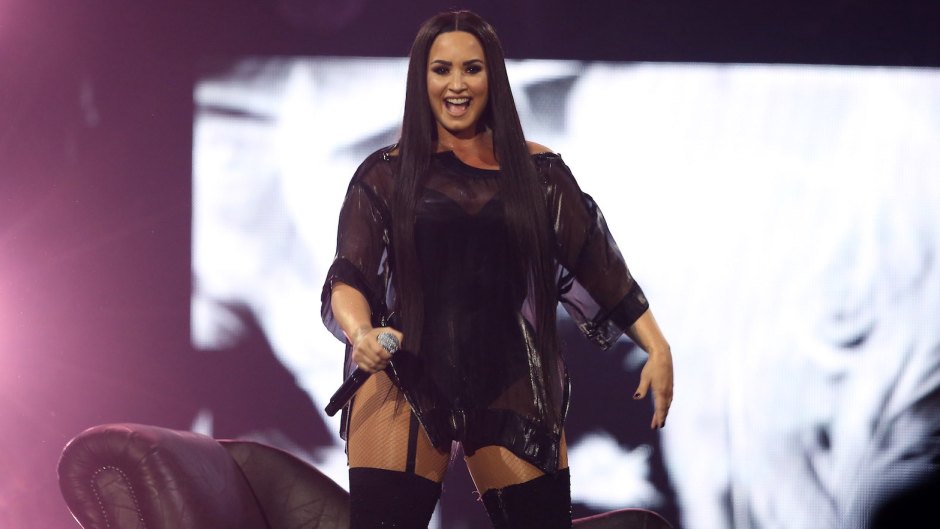 Demi Lovato wearing a black dress onstage