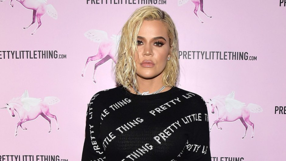 Khloe Kardashian Wearing a Black Shirt in Front of a Pink Background