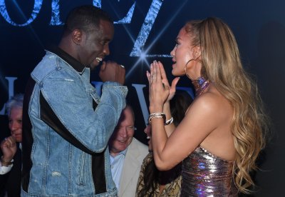 Jennifer Lopez Holding Her Hands Together With P.Diddy Wearing a Jean Jacket