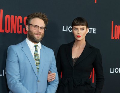 Seth Rogen Wearing a Blue Suit with Charlize Theron in a black Suit
