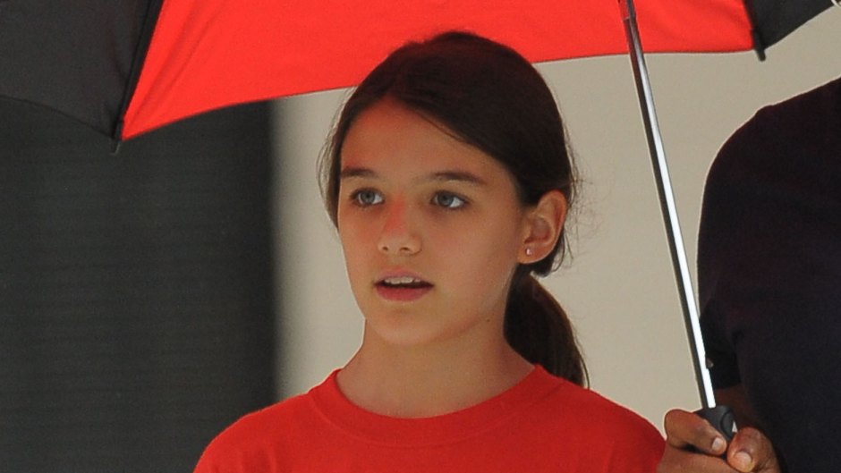 Suri Cruise Wearing a Red Shirt With an Umbrella