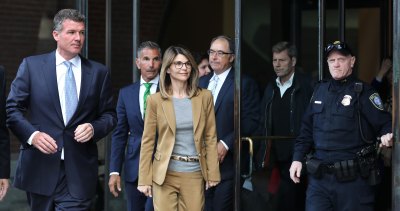 Lori Loughlin Wearing a Brown Suit in Boston With Her Husband Mossimo Giannulli Behind Her
