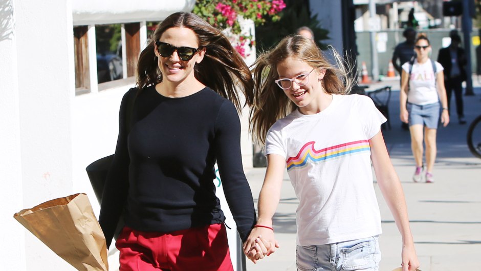 Jennifer Garner Wearing Red Shorts With a Black Shirt With Daughter Violet Holding Hands