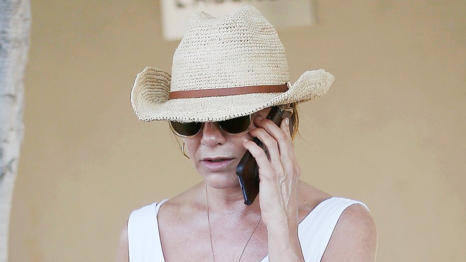 Jennifer Aniston Wearing White on Her Phone With a Hat