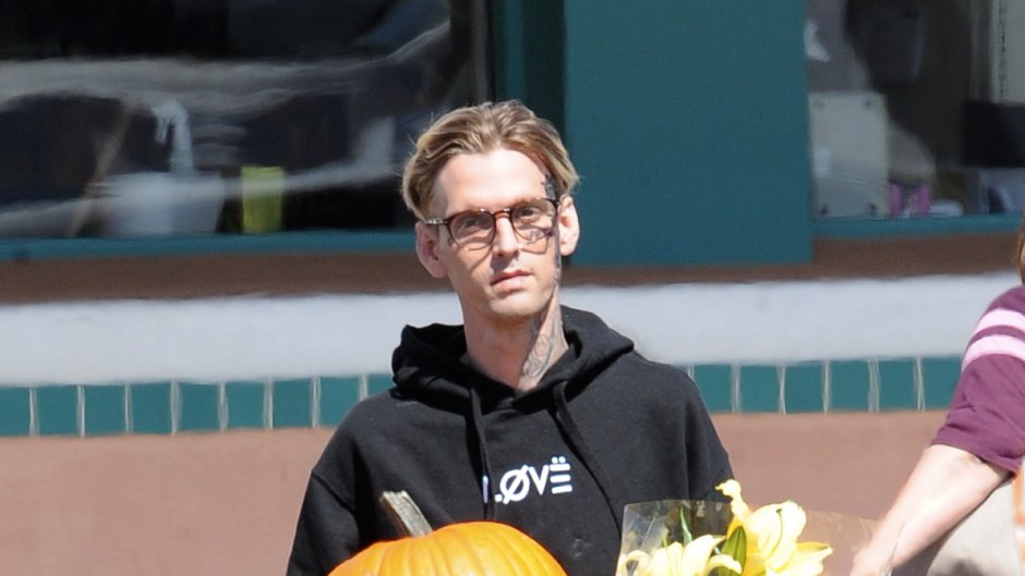 Aaron Carter Carrying Flowers and a Pumpkin Wearing all Black