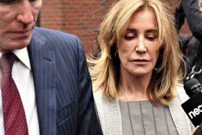 Sad Faced Felicity Huffman Looking Down Wearing White Cardigan and Gray Blouse