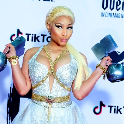 Nicki Minaj Wearing a Silver Outfit Carrying Her Grammys