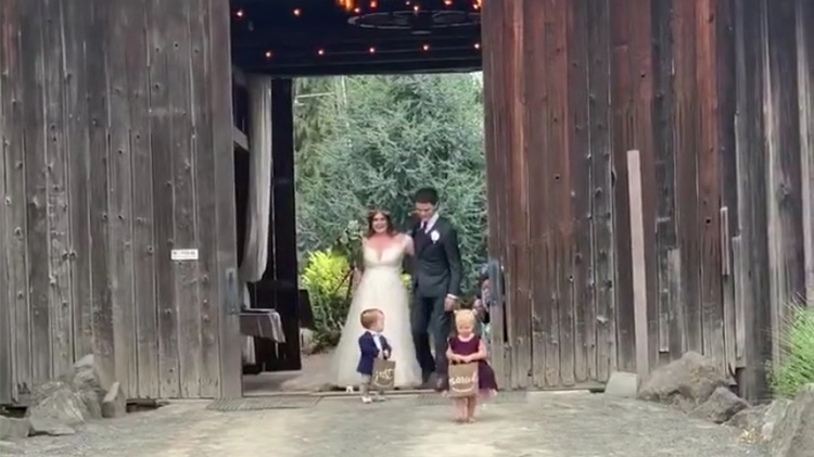 jackson and ember roloff hold 'just married' signs at their uncle jacob and aunt isabel's wedding