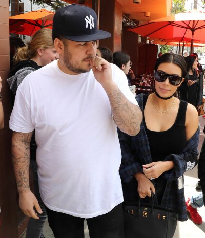 Rob Kardashian Wearing a White T-Shirt With a Yankees Hat With Kim Kardashian in Sunglasses