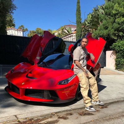 Tyga Standing in Front of a Red Car
