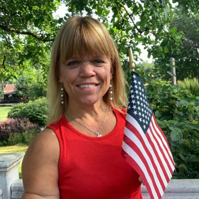 amy roloff holding flag and smiling