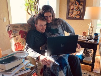molly roloff sitting on joel silvius' lap while the look at a laptop