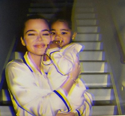 Khloe Kardashian Smiles and hugs Daughter True in White Silk Pajamas
