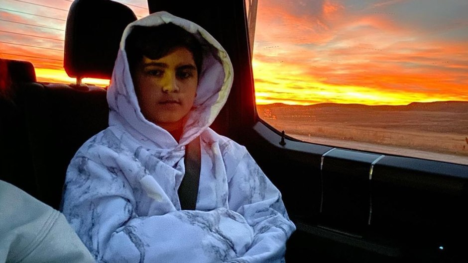Mason Disick Sits in a Car Wearing a White Striped Hoodie