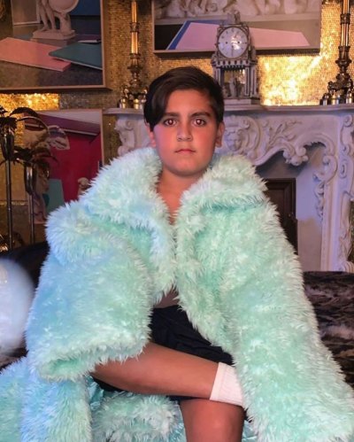 Mason Disick Sits Seriously Wrapped in Turquoise Coat