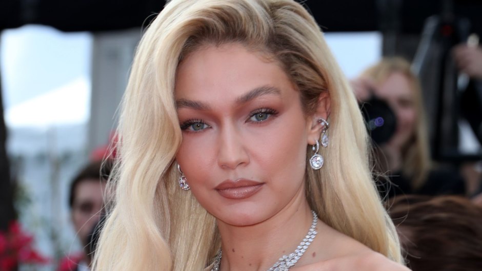 GIgi Hadid poses in a tan dress and silver necklace