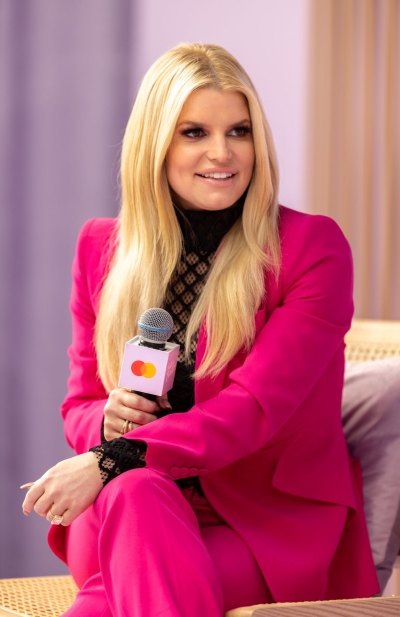 Jessica Simpson wearing a pink blazer holding a microphone