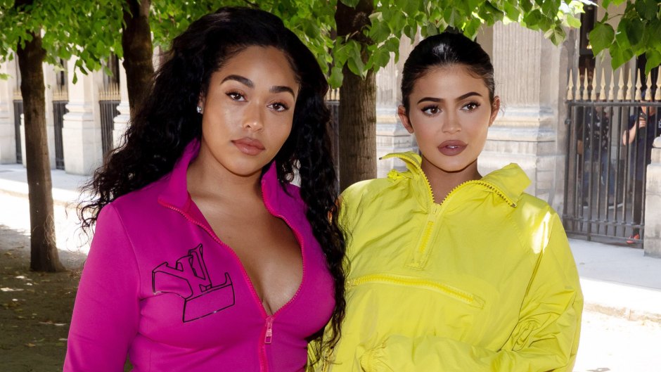 Jordyn Woods wearing a pink shirt and Kylie Jenner wearing a yellow track suit