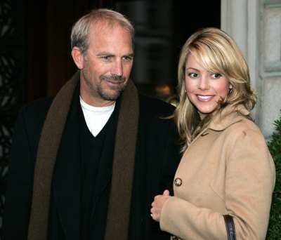 Kevin Costner and Christine Baumgartner walk outside together in 2004
