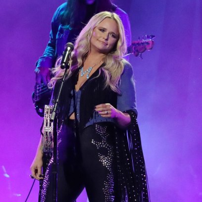 Miranda Lambert singing on stage wearing a black and blue pantsuit