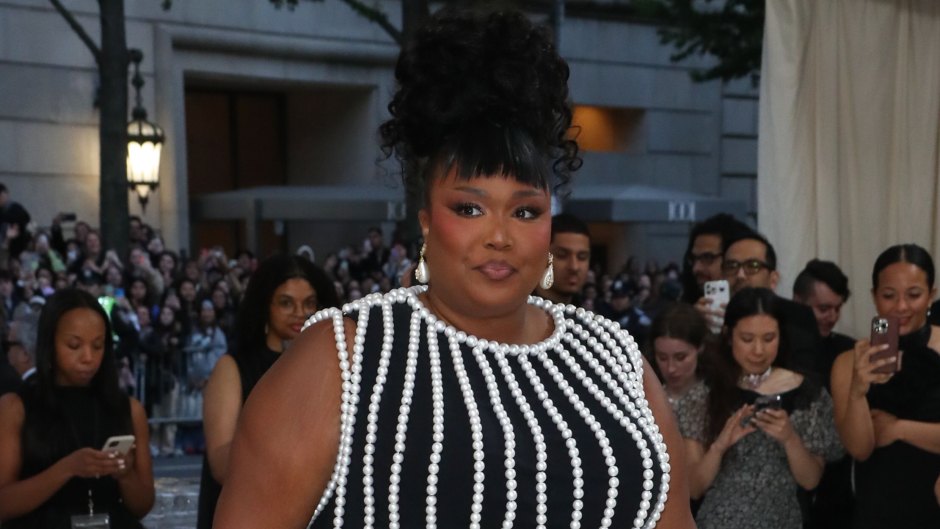 Lizzo appearing at the Met Gala in a black dress with pearls
