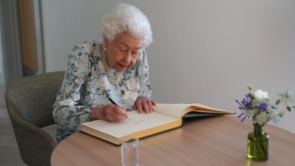 Queen Elizabeth II signs a guestbook