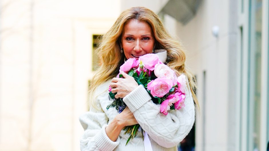 Celine Dion holds a bouquet of pink flowers while wearing a pink floral skirt