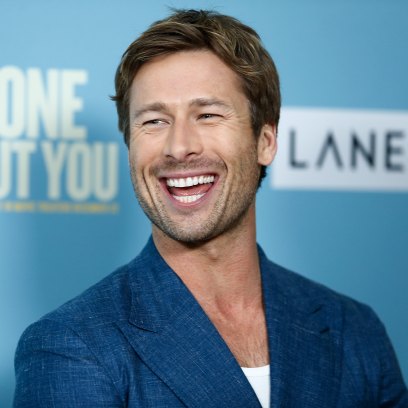 Glen Powell in a navy suit while at the Anyone But You premiere.