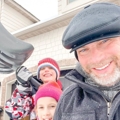 Kevin Franke with two of his children shoveling snow.
