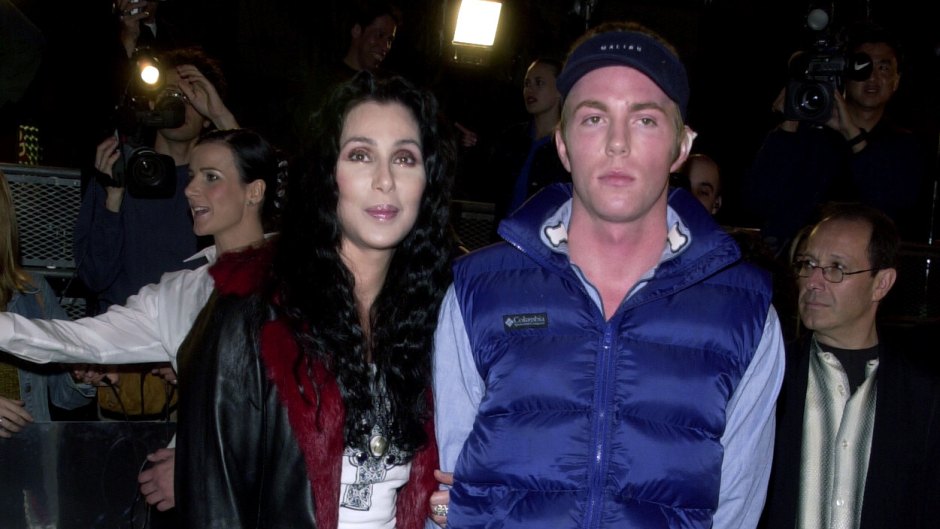 Cher poses next to son Elijah who's wearing a navy puffer vest.