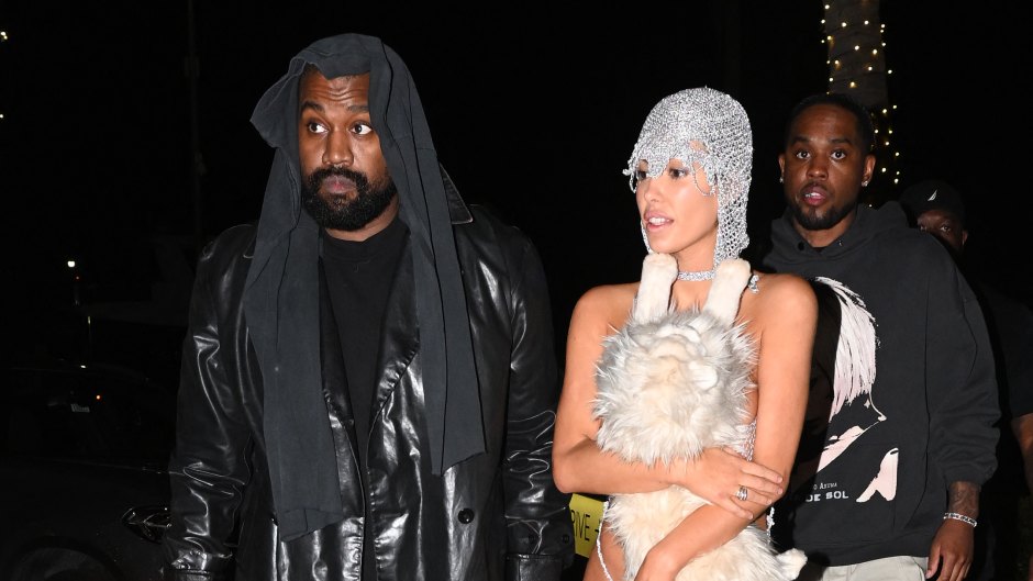 Kanye West in all black leather while wife Bianca Censori wears a sparkly silver outfit with a stuffed cat.