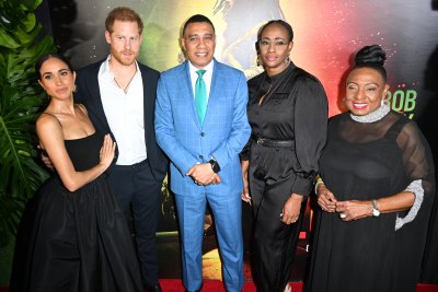 Meghan Markle, wearing a black skirt and black top, poses next to Prince Harry, Andrew Holness, Juliet Holness and Olivia Grange