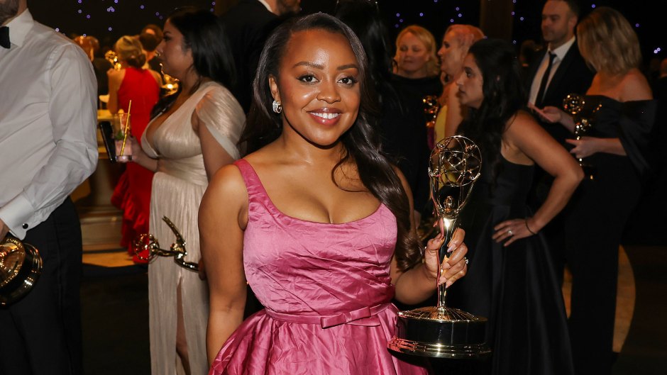Quinta Brunson wears a dark pink dress and holds an Emmy Award