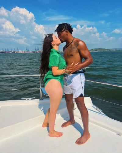 Teen Mom's Kayla Sessler wearing a green tshirt over a bikini while kissing Ryan Leigh on a boat